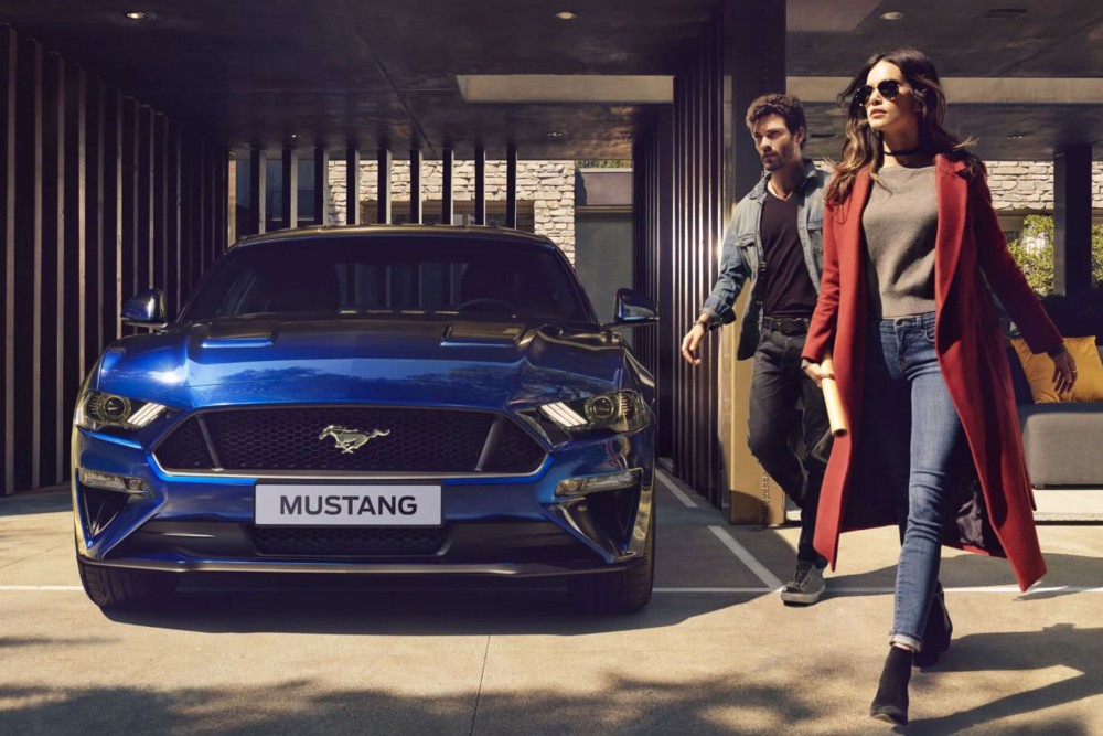 Niebieski Ford Mustang zaparkowany przed domem