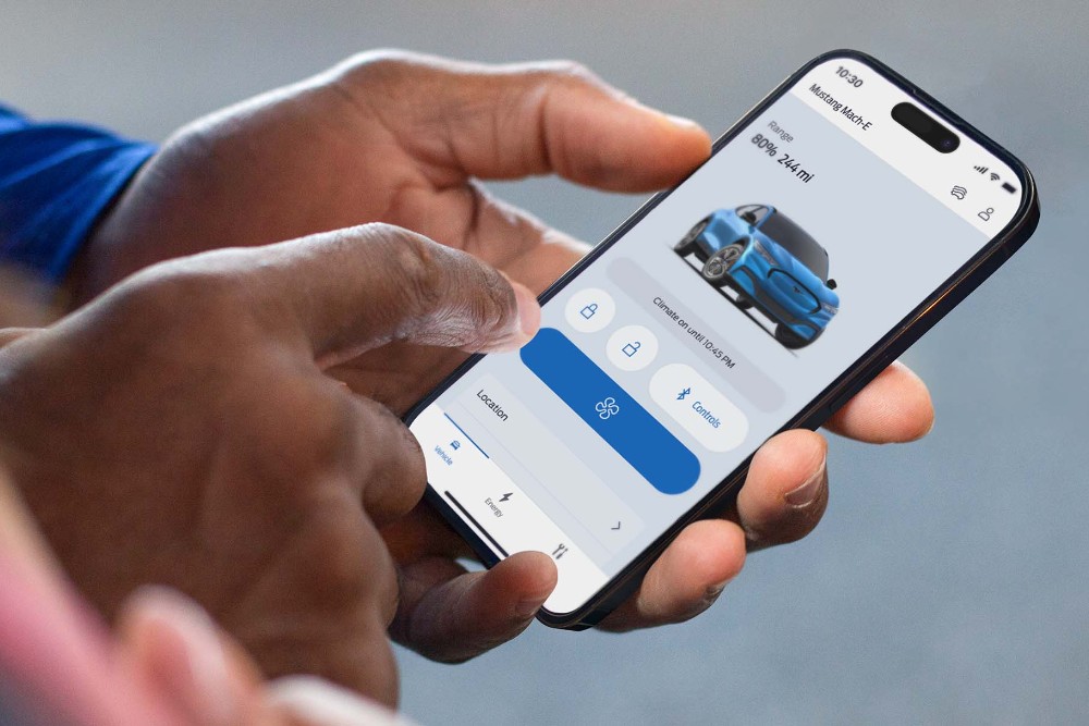 Man holding a phone using remote locking on the FordPass App