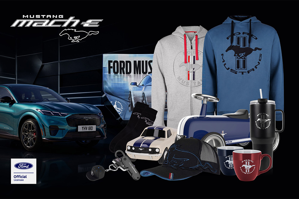 Ford merchandise collection featuring various Ford vehicles in the background with Ford branded umbrella, mugs, and clothing items.