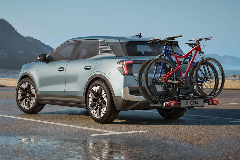  Blue Ford Explorer® driving through a rugged mountain landscape, with two bicycles on the roof rack.