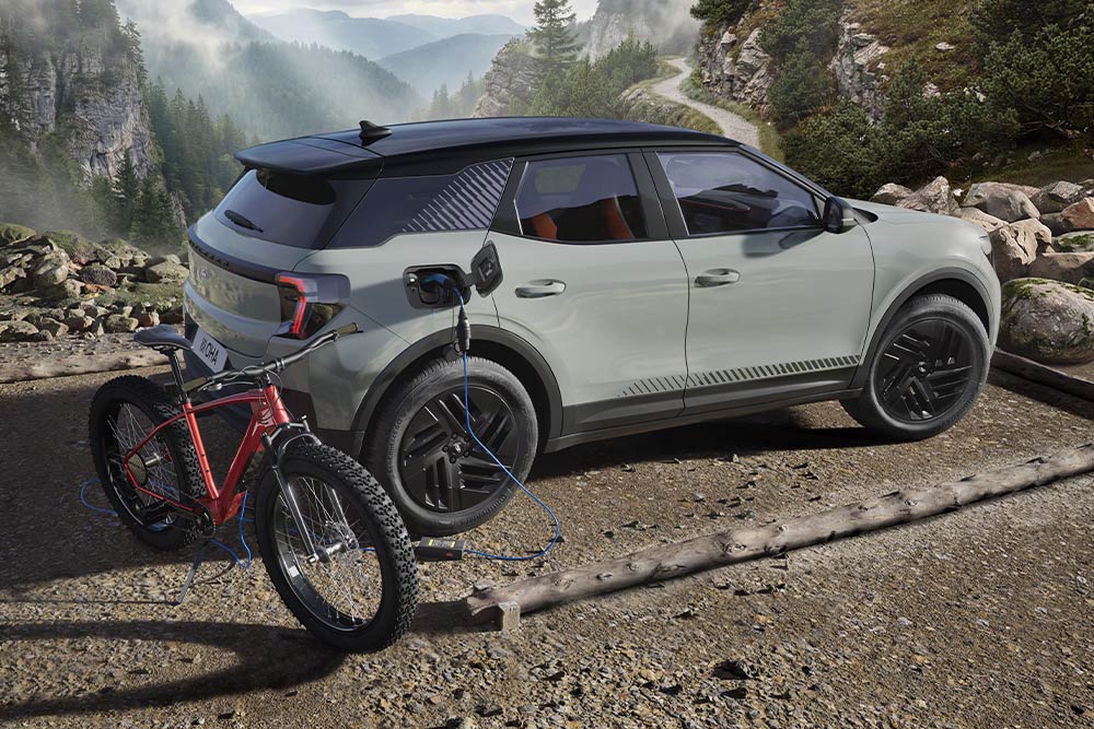Ford Explorer® ładujący elektryczny rower na tle górskiego krajobrazu.
