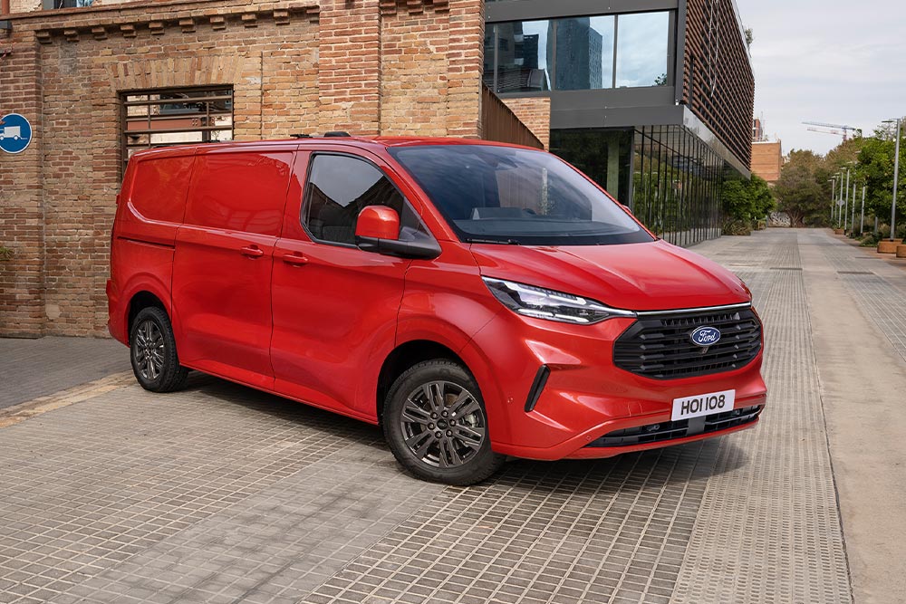 Czerwony van Ford Transit Custom zaparkowany na ulicy.