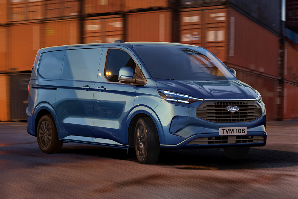 Niebieski van Ford Transit Custom Plug-in Hybrid przejeżdża przez teren stoczni.