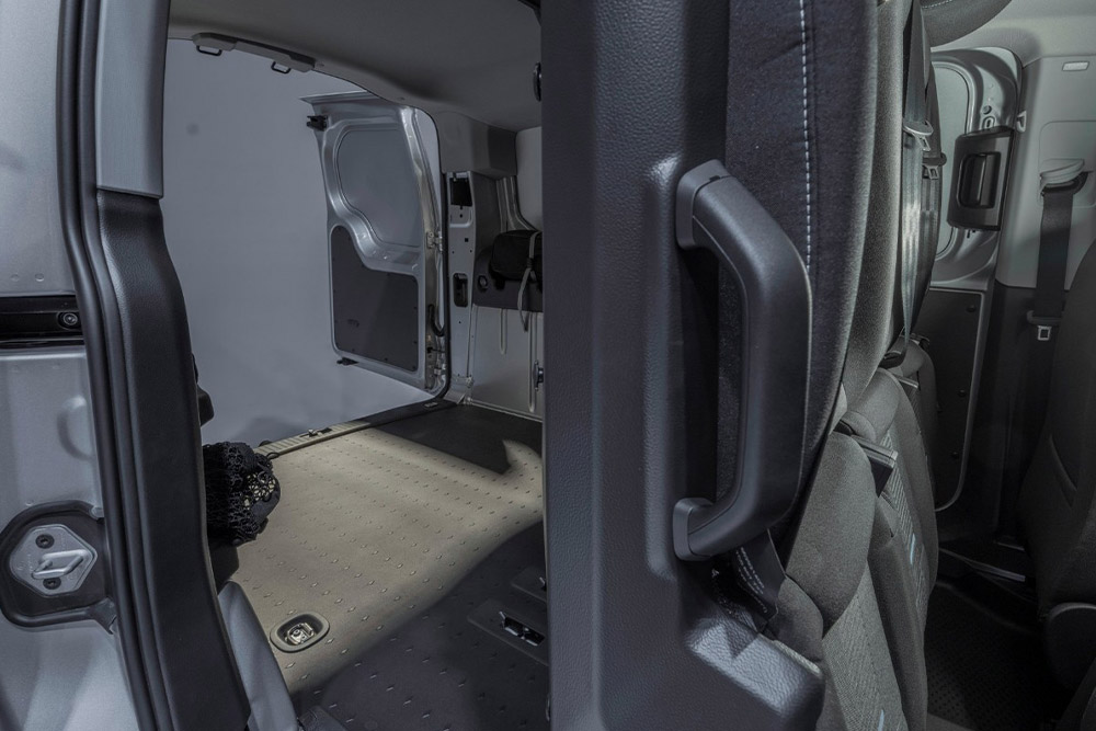 Wnętrze Forda Transit Connect FlexCab ze złożonymi tylnymi fotelami i pustą przestrzenią ładunkową.