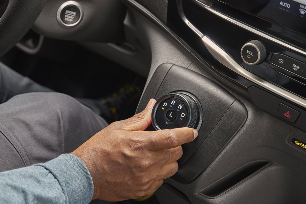 Close-up of a hand operating the rotary gear selector in a Ford Transit Minibus.