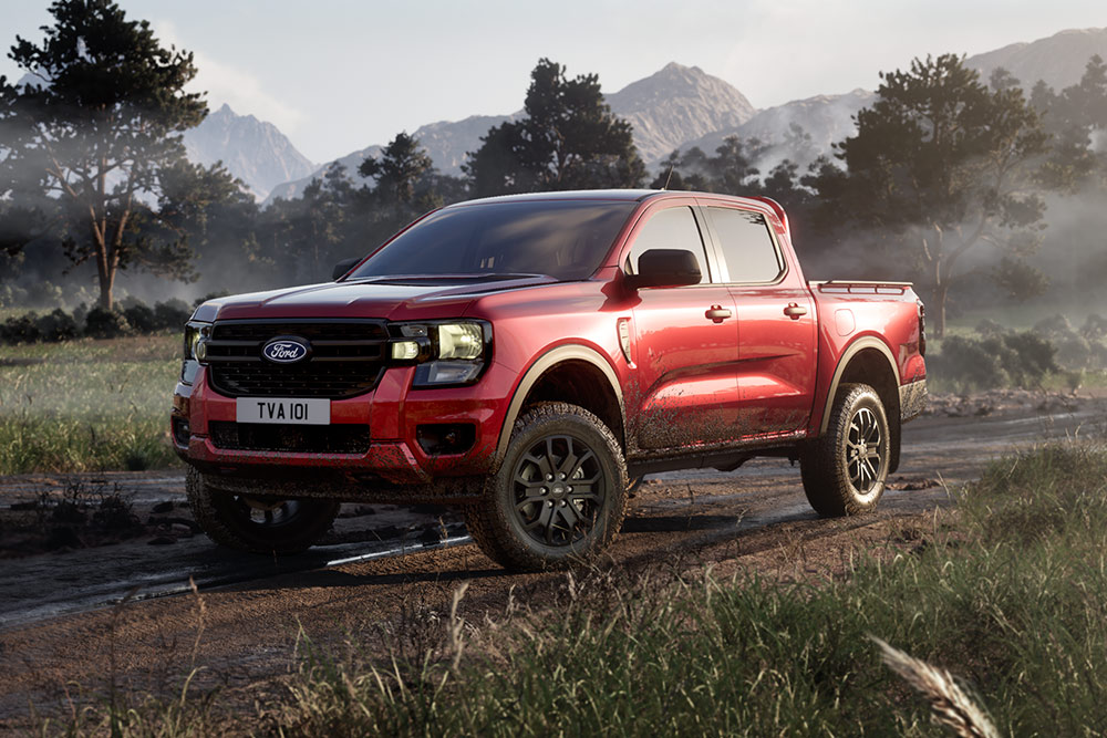 Czerwony Ford Ranger Raptor wznosi tumany kurzu, przejeżdżając przez malowniczy atrakcyjny krajobraz.
