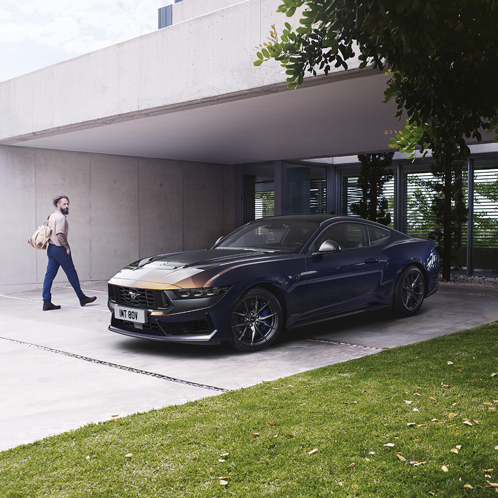 Zaparkowany Ford Mustang Dark Horse i człowiek wchodzący do domu